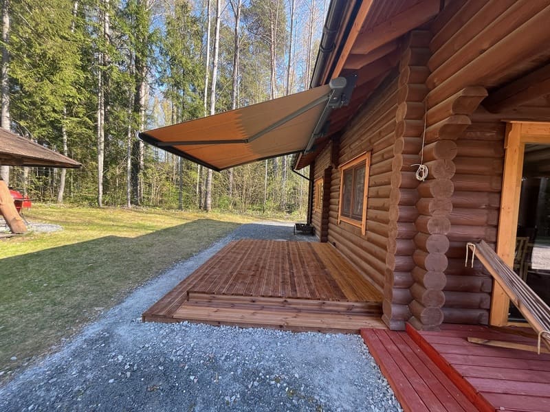 Brun markis fäst vid trähus med veranda