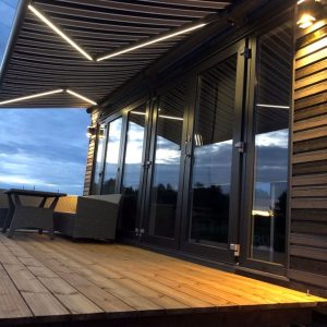 Markis med LED-belysning på träterrass vid skymning