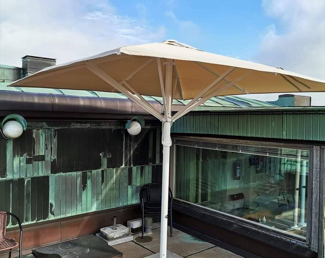 Beige parasoller på terrasstak vid moderna byggnader
