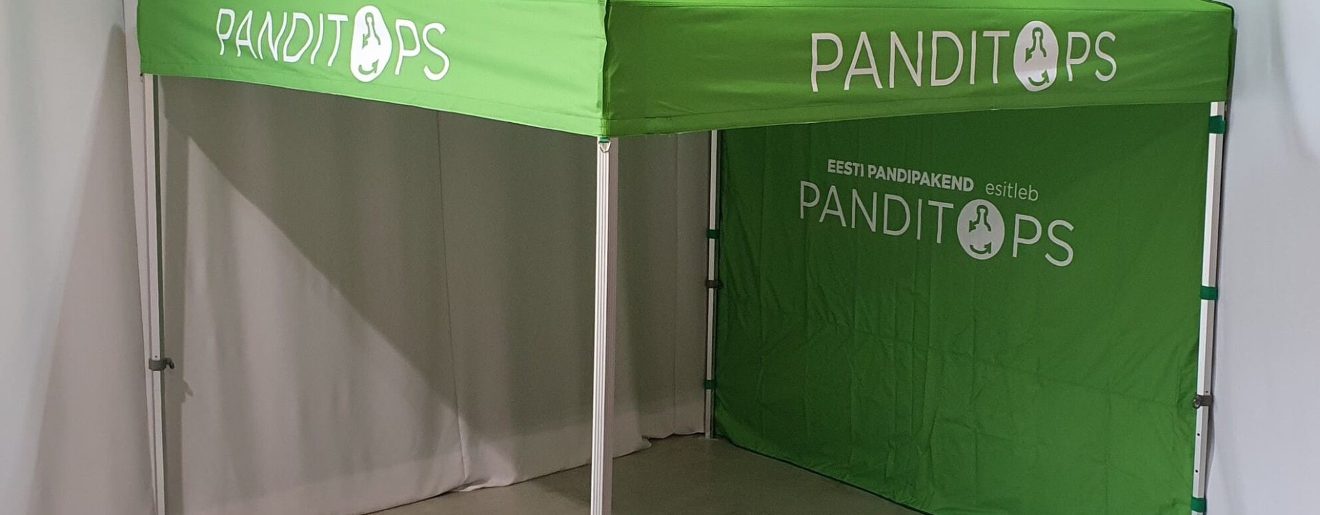 grön PANDITOPS-mainostält sisätiloissa, med on sivuväggt ja metallinen ram
