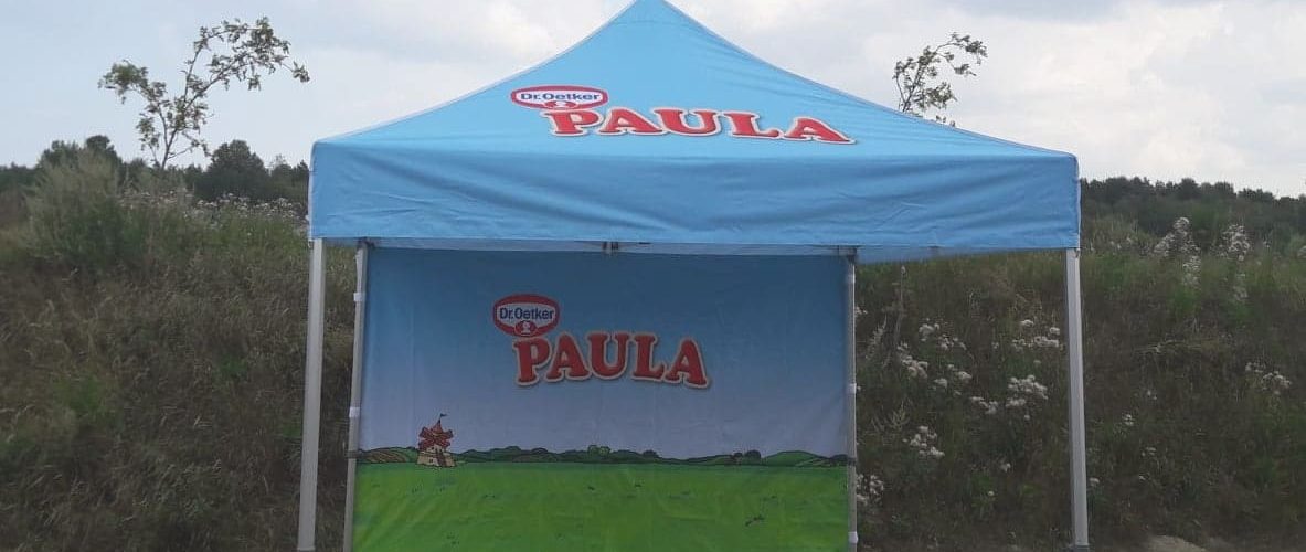 Dr. Oetker Paula blå tält ulkotilaesittelyssä, maisemavikttteisella grafiikalla