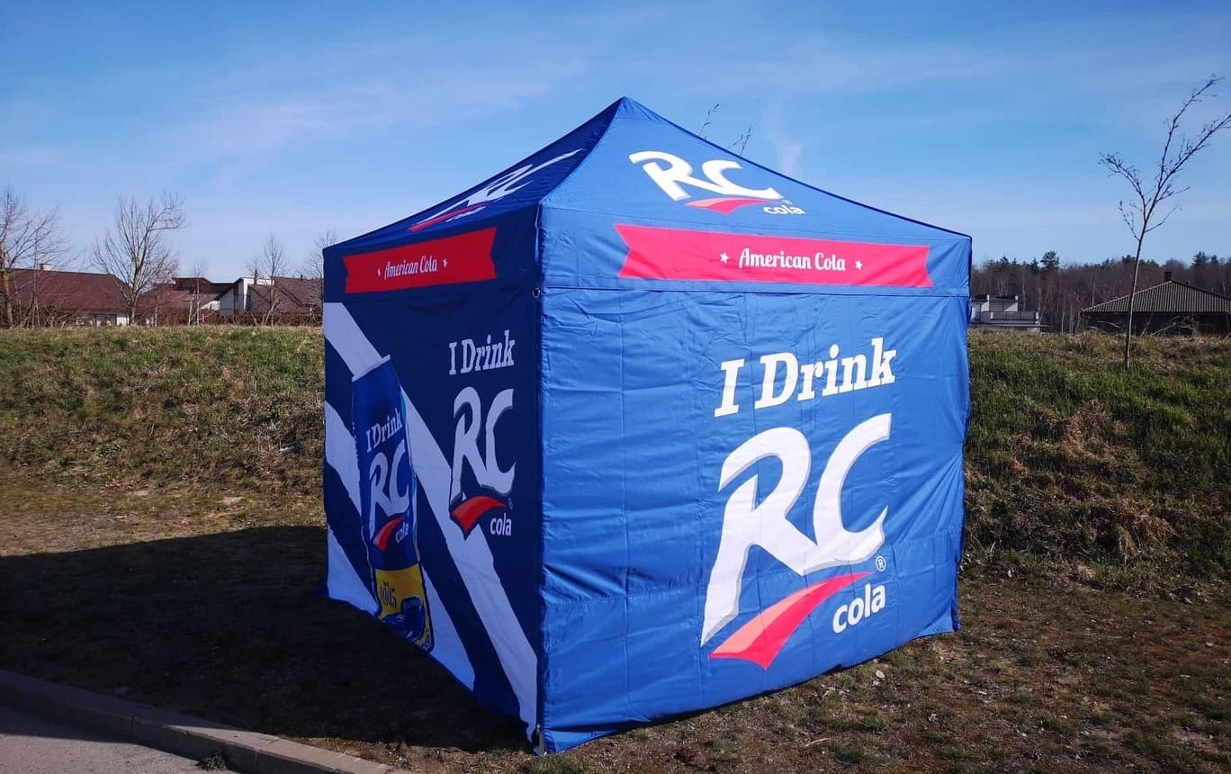 blå RC Cola mainostent ulkona pihalla, teksti "I Drink RC" näkyvillä teltan sivuilla