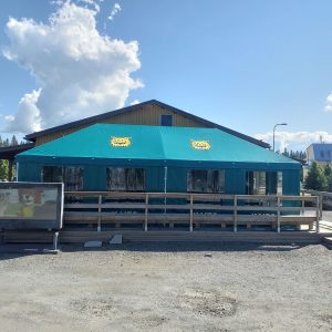 Turkoosi värisellä dukkatolla utrustad ravintola tai kahvila puisella på terrass.