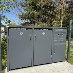 Grå sopkärl med postlåda i trädgårdsmiljö